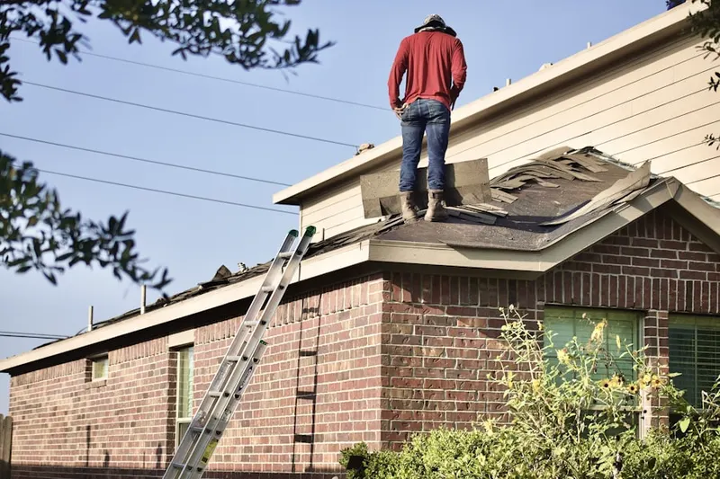Professional roofer working on a residential roof in Leasburg